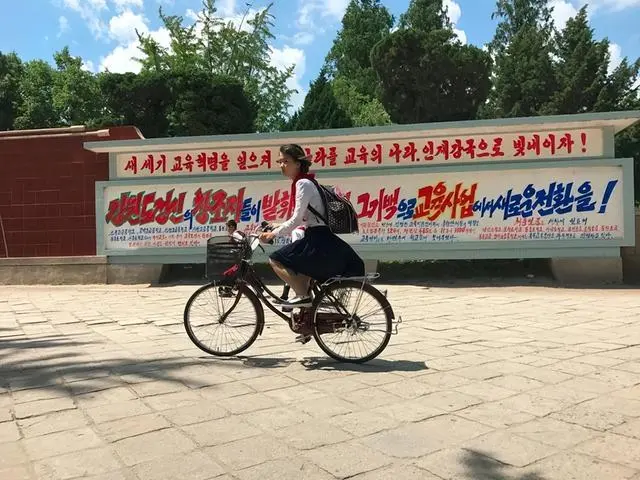 The streets of Pyongyang, North Korea, are a scene of rare cars with headlights on during the day and beautiful traffic police standing guard